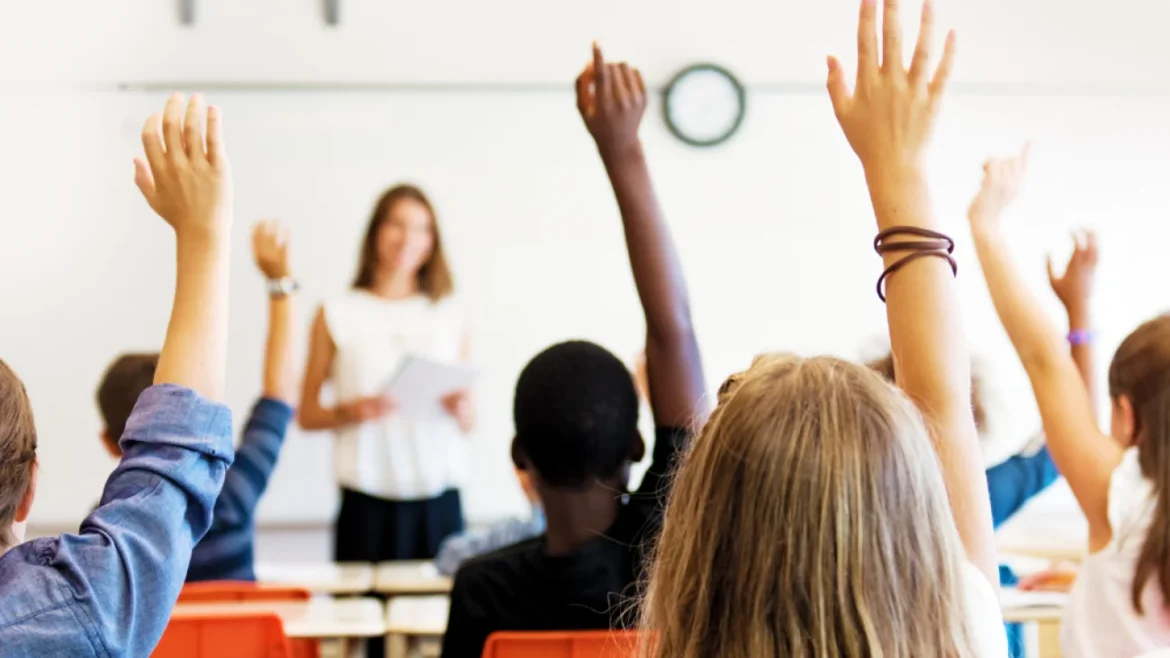 Students raising hands classroom