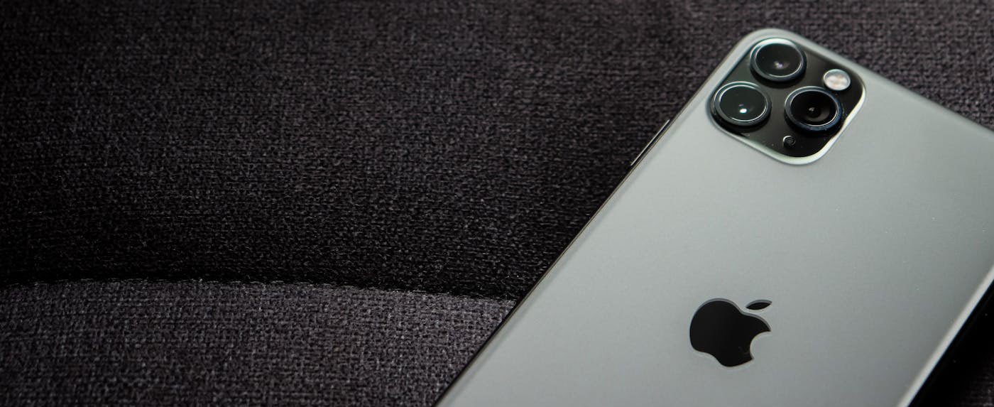 Dark Titanium iPhone 17 Pro Max from the iPhone 17 Series showing the brushed metal chassis on fabric.